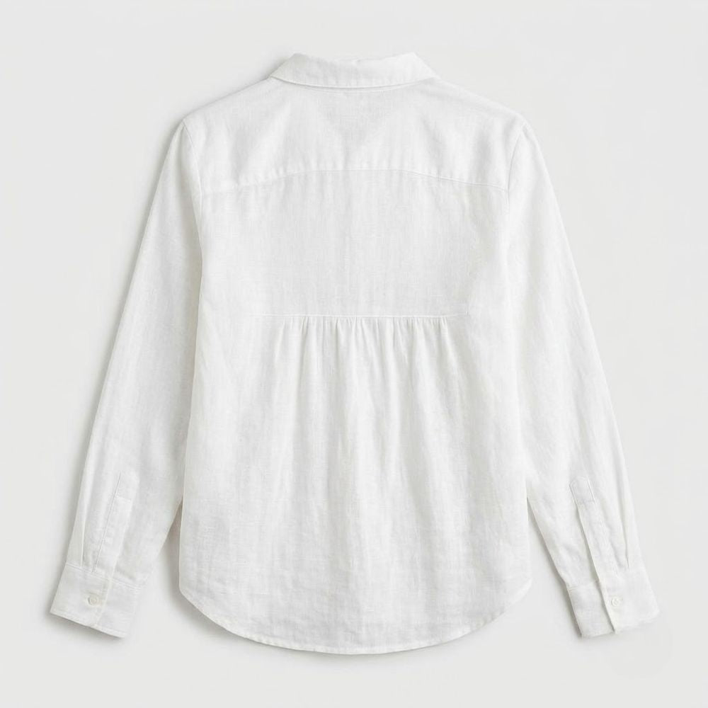 Blusa feminina branca em linho de corte solto, com gola clássica, mangas compridas e bainha arredondada vista de costas.